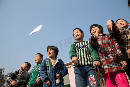 纸飞机飞机摄影照片_乡村小学生在学校放纸飞机