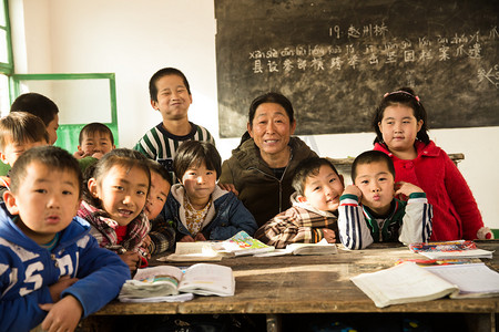 合家欢乐大团圆摄影照片_乡村女教师和小学生在教室里