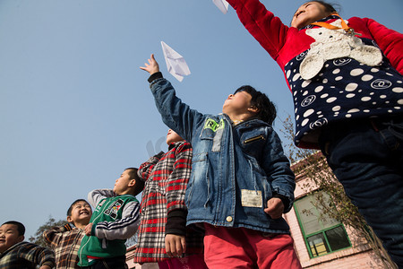 红领巾摄影照片_乡村小学生在学校放纸飞机