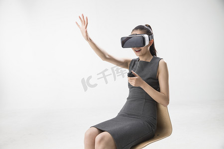 戴眼镜马尾辫摄影照片_戴着VR眼镜的青年女人