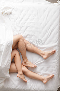 四肢发凉摄影照片_青年情侣在床上睡觉