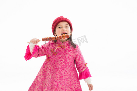元旦喜庆的背景摄影照片_欢乐的小女孩吃糖葫芦