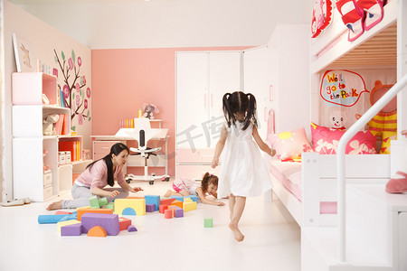 青年女人和两个女孩在卧室玩耍