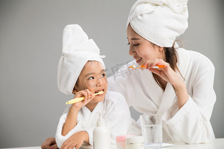 关爱口腔健康摄影照片_穿着浴袍的母女刷牙