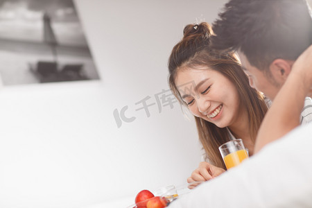 七夕节快乐字体摄影照片_青年情侣在床上吃早餐