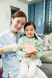 牙医椅摄影照片_可爱的小女孩和牙医