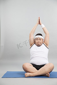 肥胖的青年男人在做瑜伽
