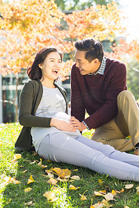 落叶草地摄影照片_丈夫陪着怀孕的妻子在户外