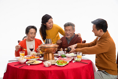 吃火锅的女人摄影照片_幸福家庭过年吃团圆饭