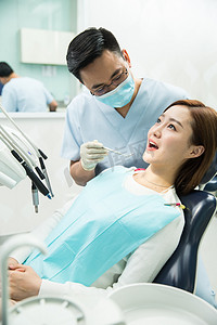 牙科诊疗室摄影照片_男牙医和女患者