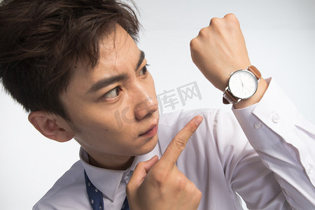 扭曲的时间摄影照片_戴着腕表的商务青年男人