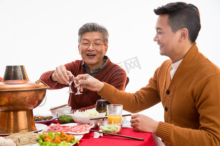 老年人喝酒摄影照片_父子俩吃年夜饭喝酒