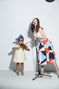 拉小提琴摄影照片_小女孩和妈妈拉小提琴