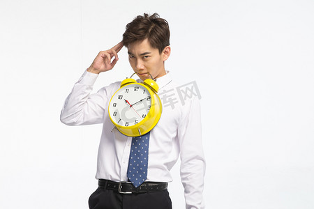 核对时间摄影照片_商务青年男人拿着闹钟