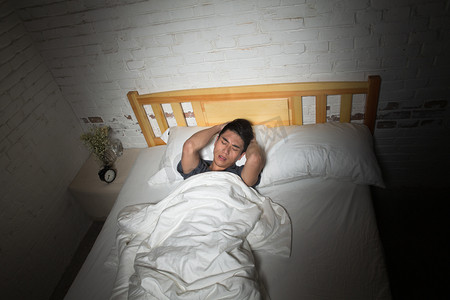 卧室被子摄影照片_青年男人失眠