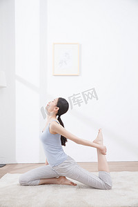 起居室摄影照片_青年女人练习瑜伽