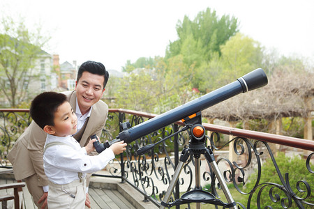 望远镜观星插画摄影照片_父亲和儿子在阳台使用天文望远镜