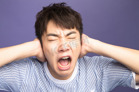 夸张图片摄影照片_青年男人捂着耳朵