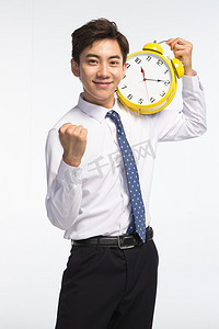 抢时间摄影照片_商务青年男人拿着闹钟