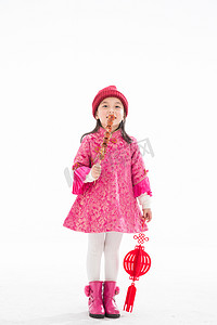 吃帽子摄影照片_欢乐的小女孩吃糖葫芦