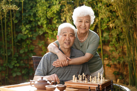 女人坐着摄影照片_幸福的老年夫妇在院子里