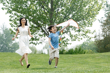 风筝风筝摄影照片_快乐母子在草地上放风筝