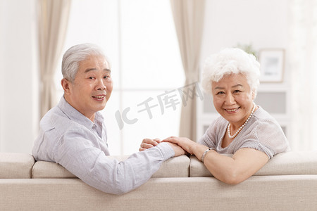 老人沙发摄影照片_幸福的老年夫妇在客厅