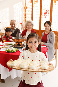 全家福饺子摄影照片_小女孩过年端着饺子