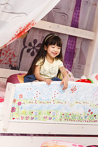 傣族卡通摄影照片_可爱的小女孩在床上玩耍