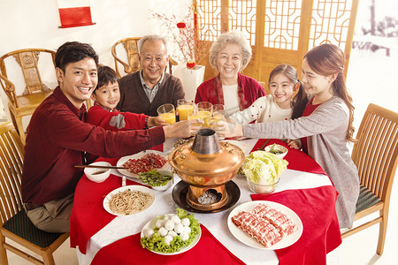 吃火锅的女人摄影照片_幸福家庭过年吃团圆饭