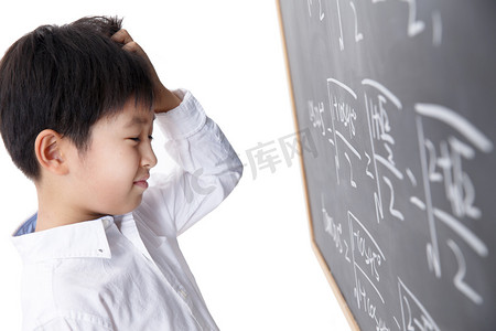 做数学题摄影照片_小学男生被数学题难住