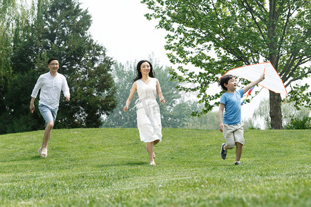 一家三口在草地上放风筝