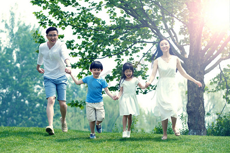 可爱奔跑摄影照片_快乐家庭在草地上奔跑