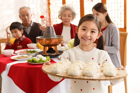 全家福饺子摄影照片_小女孩过年端着饺子