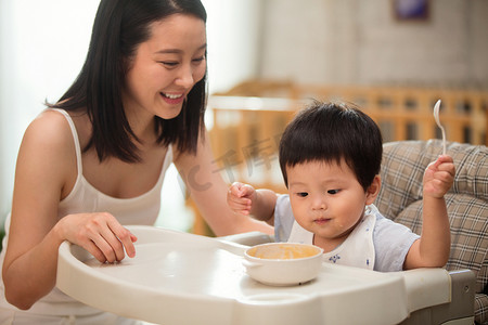 妈妈喂宝宝吃饭摄影照片_妈妈喂宝宝吃饭