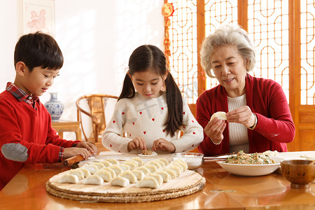 包饺子儿童摄影照片_老人教孩子们学包饺子