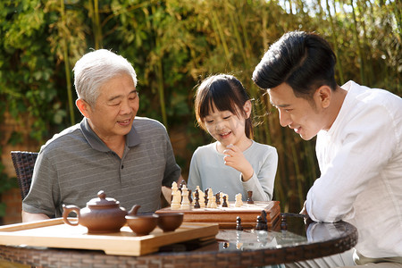重阳节快乐摄影照片_祖孙三代在庭院里下棋