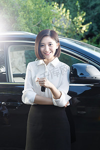 轿车美女摄影照片_青年女人拿着车钥匙站在汽车旁边