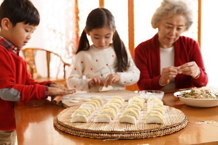 包饺子儿童摄影照片_幸福家庭过年包饺子