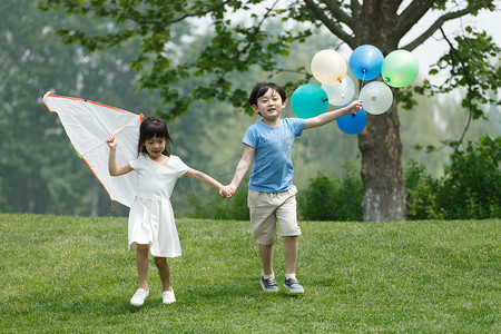 手绘儿童节海报摄影照片_快乐儿童在草地上玩耍