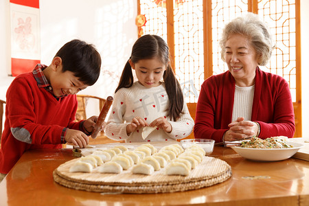 喜庆的元旦快乐摄影照片_幸福家庭过年包饺子