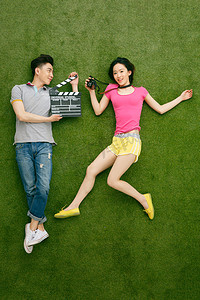 青年情侣躺在草地上玩耍