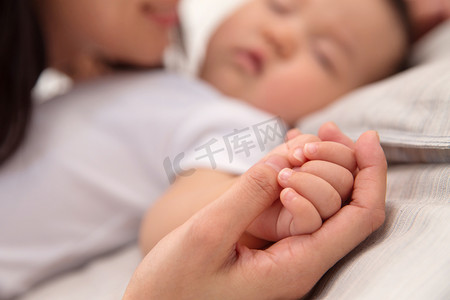 躺着睡觉的婴儿摄影照片_妈妈和宝宝的手
