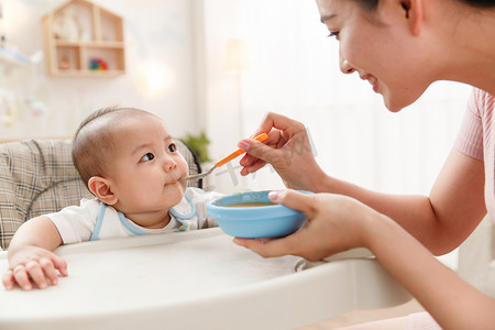 吃饭用品摄影照片_妈妈喂宝宝吃饭