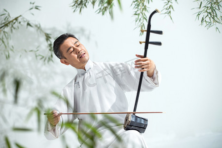 中国古典乐器摄影照片_男艺术家在拉二胡