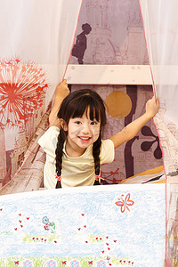 幸福的卡通女孩摄影照片_可爱的小女孩在床上玩耍