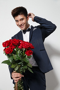 喜庆玫瑰花摄影照片_青年男人拿着玫瑰花
