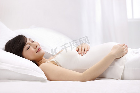 怀孕图片摄影照片_孕妇躺在床上睡觉