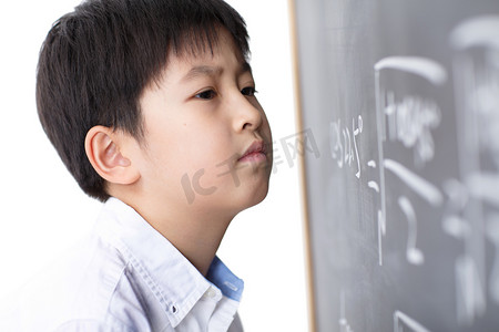 做数学题摄影照片_小学男生被数学题难住