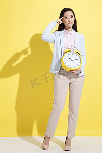 白领摄影照片_青年商务女士拿着钟表